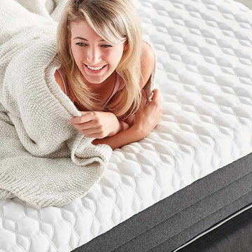 smiling blonde lady lying on mattress